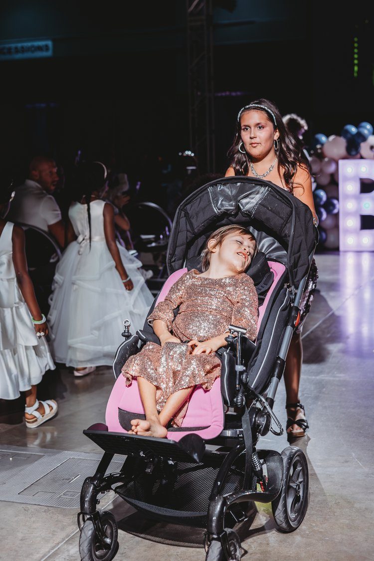 A teen model with arms outstretched celebrating on the Beautifully Loved runway